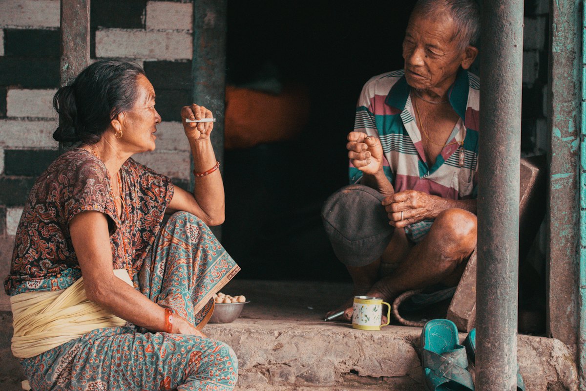 An older couple sitting on steps, talking
